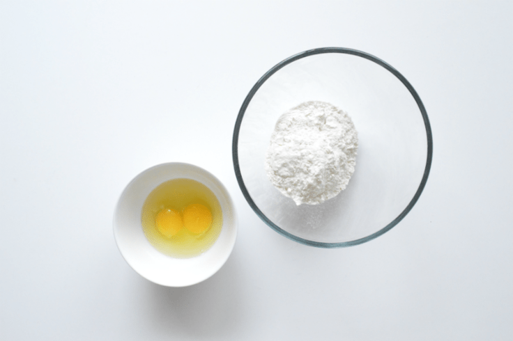 2 mixing bowls with eggs and flour.