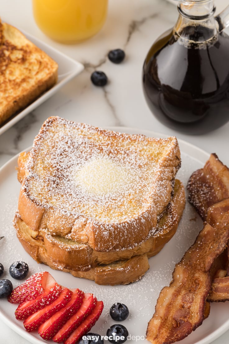 Stack of french toast with powdered sugar.