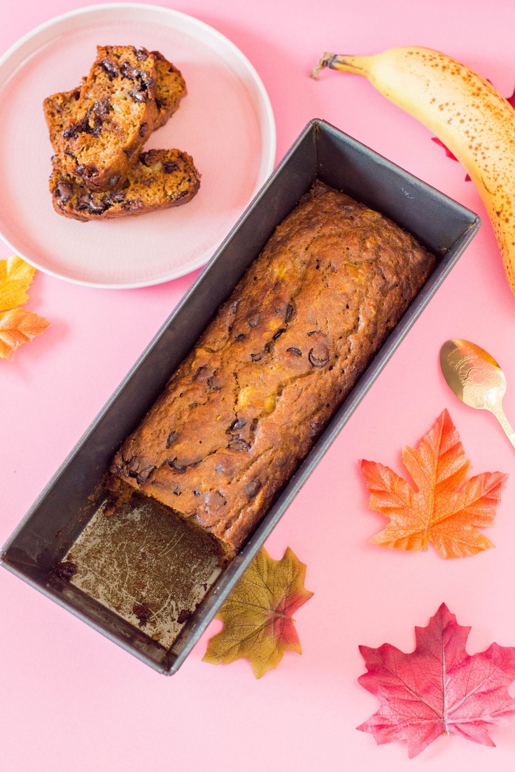 A loaf pan of pumpkin banana bread with chocolate chips.