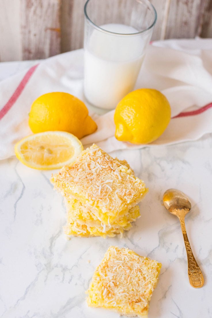 A stack of coconut lemon bars on a kitchen counter.