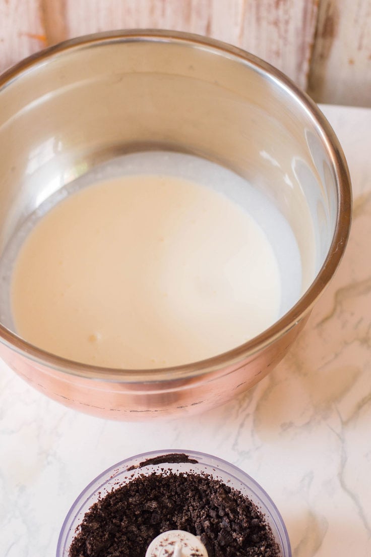 Heavy cream in a stand mixer bowl.