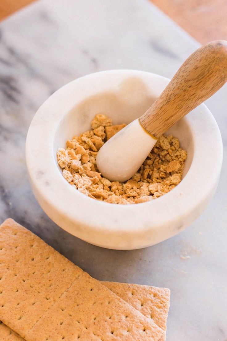 Graham cracker crumbs with a mortar and pestle.