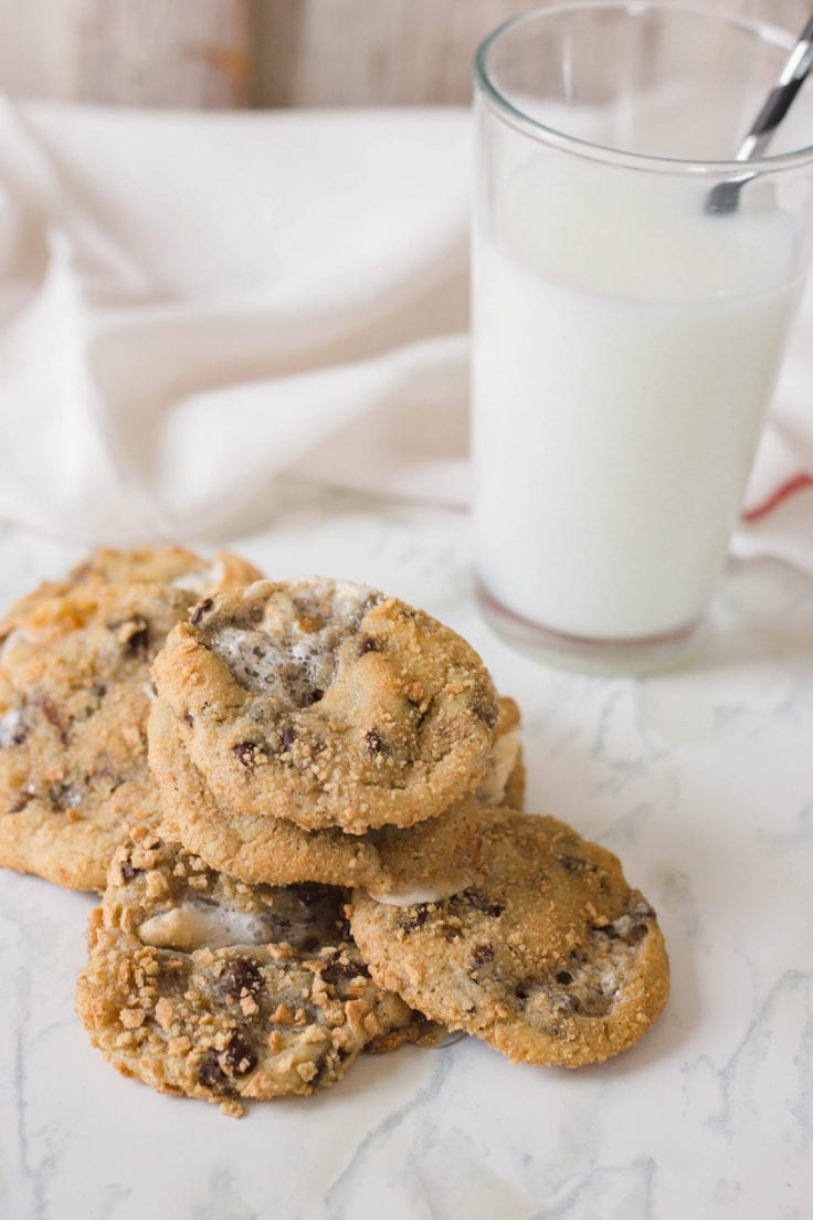 Baked cookies on a countertop beside a glass of milk.