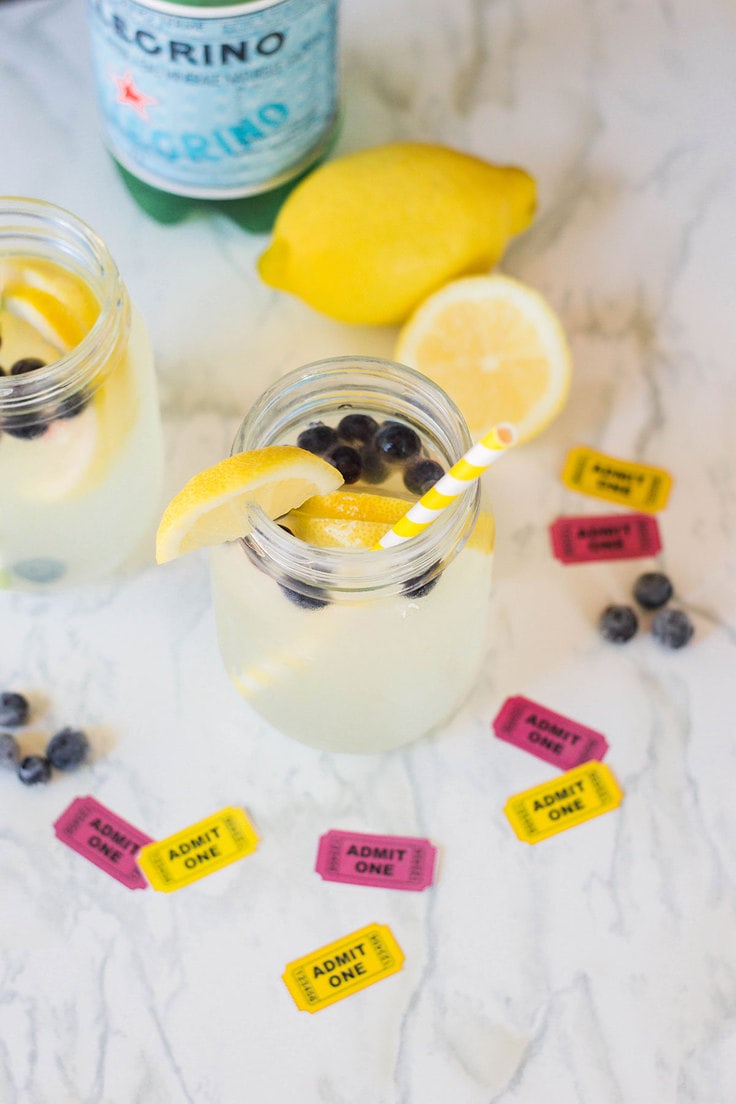 Sparkling lemonade with blueberries in glasses on a kitchen counter.