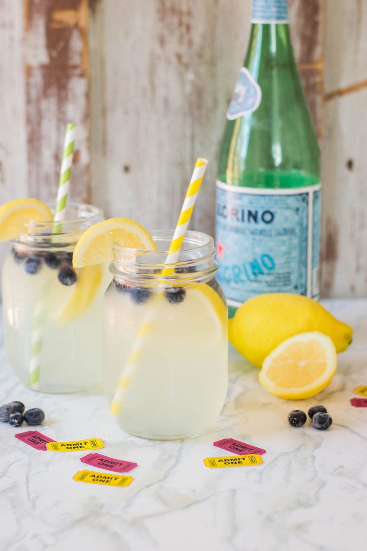 Glasses of sparkling lemonade with blueberries and lemon slices.