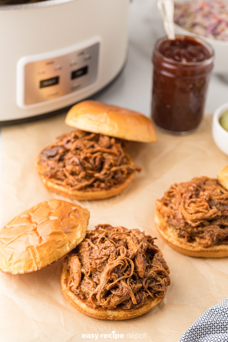 pulled pork sandwiches with a slow cooker in the background