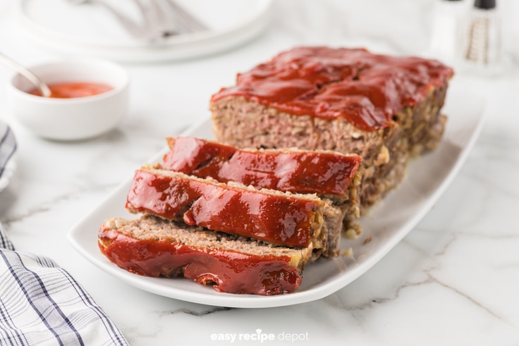 Meatloaf partially sliced on a serving tray.