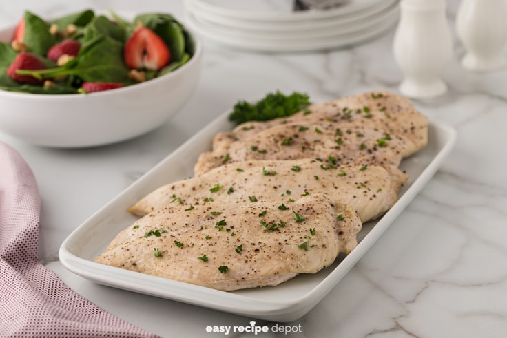 Oven baked chicken breasts served with a salad.