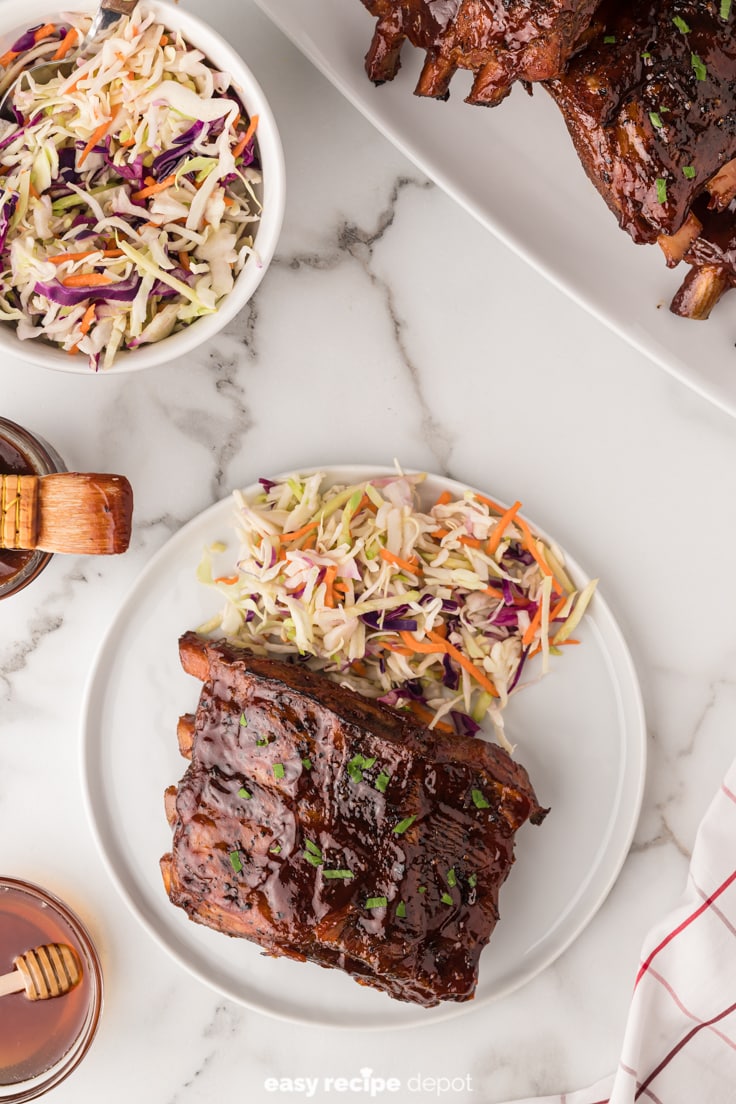 Fall off the bone slow cooker baby back ribs served with coleslaw.
