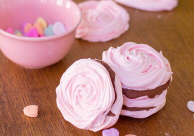 Meringue cookies pink rosette with chocolate filling.