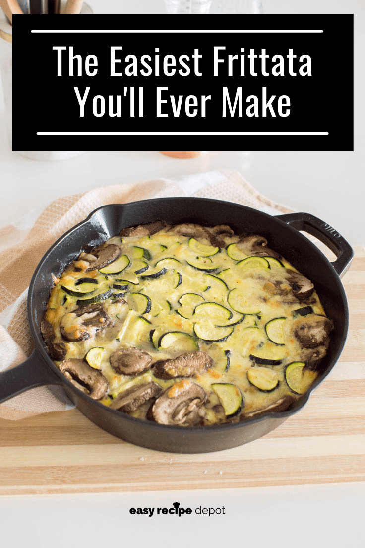 A vegetable frittata in a black cast iron skillet, sitting on top of a wooden cutting board