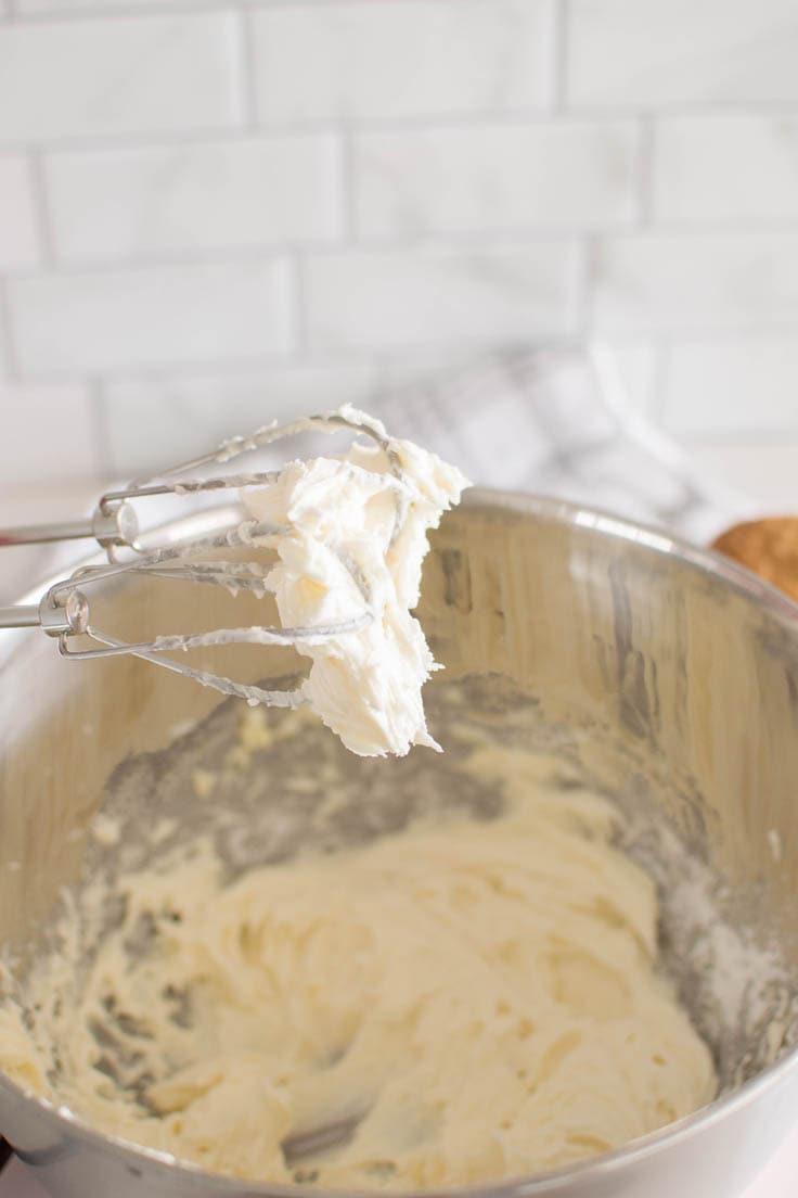 Vanilla frosting on the whisks of a hand mixer