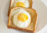 Bird's eye view of two slices of eggs in a basket, sitting on a white plate