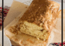 Aerial view of a loaf of cinnamon bread on parchment paper, with a slice on a small white plate