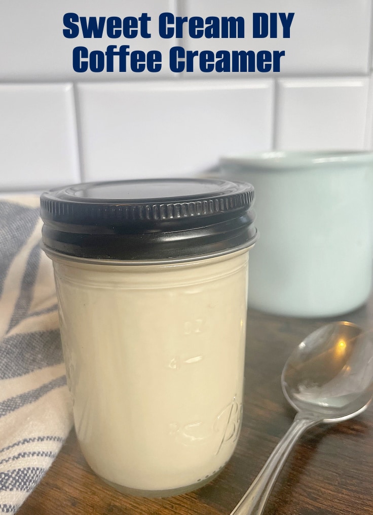 DIY coffee creamer in mason jar with a black lid and a blue coffee cup.