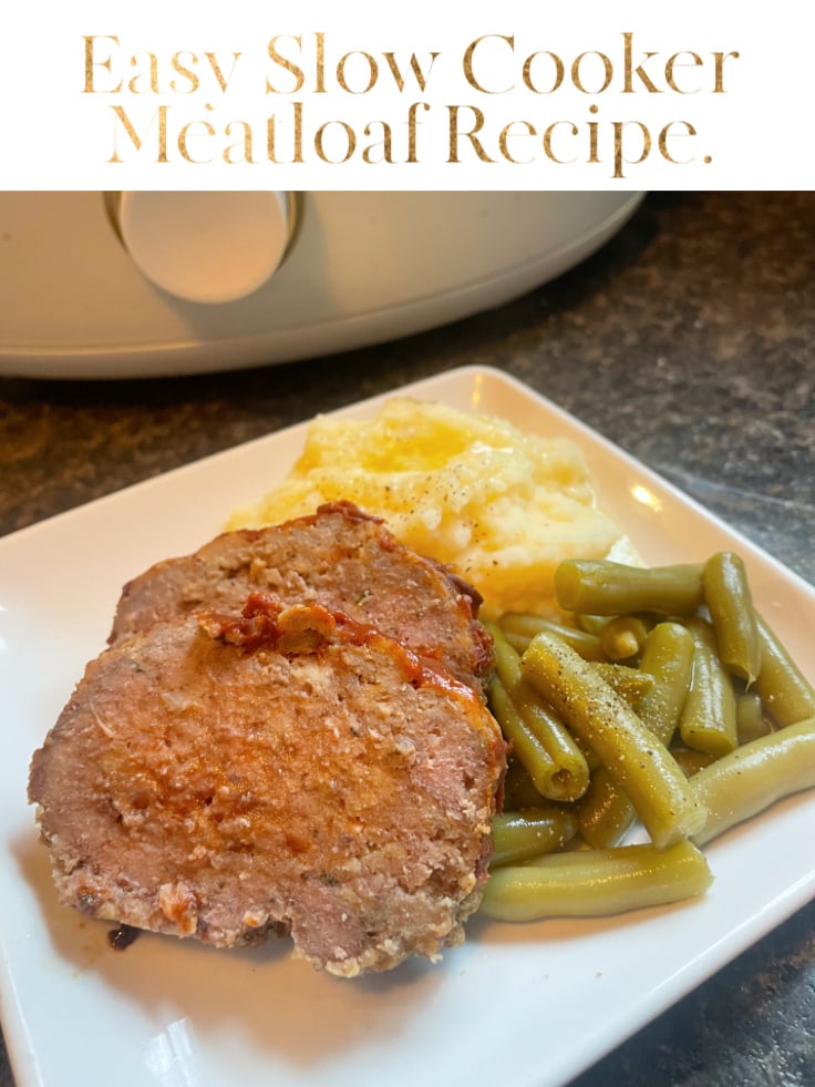 sliced meatloaf on white plate with green beans and mashed potatoes