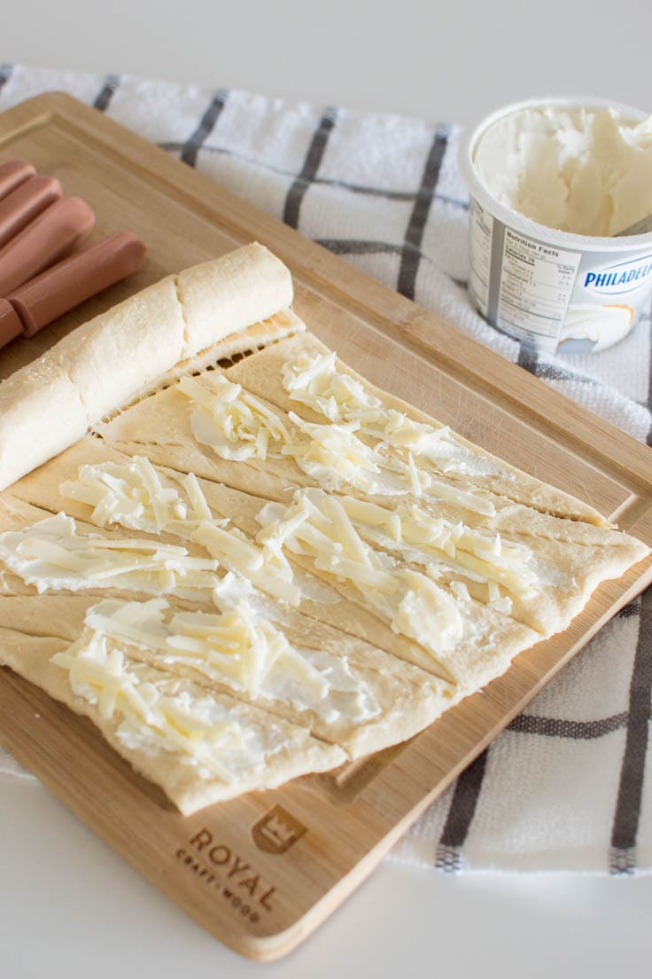 Adding cream cheese and shredded cheese on canned croissant dough