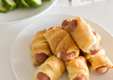 Aerial shot of pigs in a blanket on a white plate