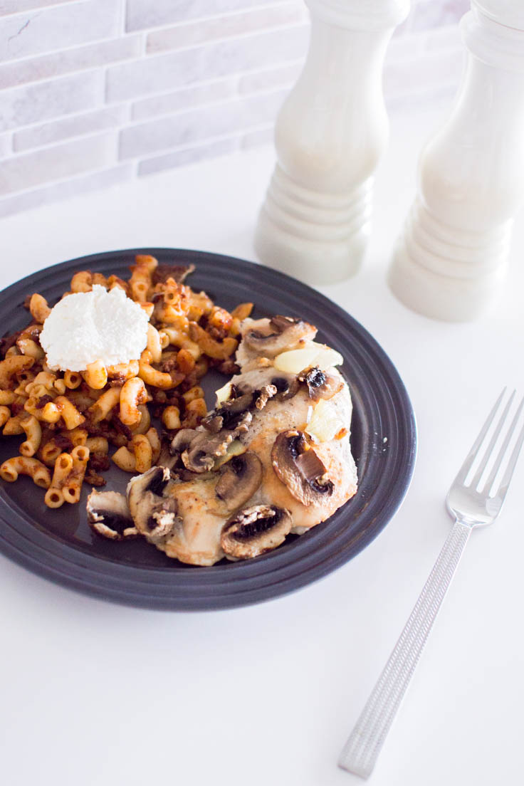 Mushroom and Onion Baked Chicken served on a grey plate with pasta