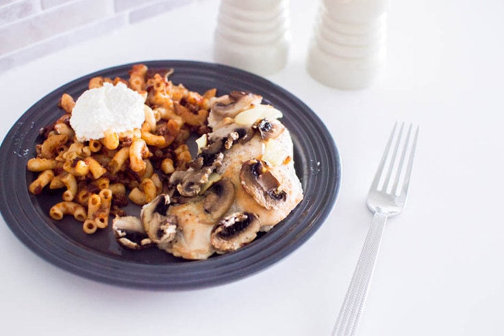 Mushroom and Onion Baked Chicken served on a grey plate with pasta