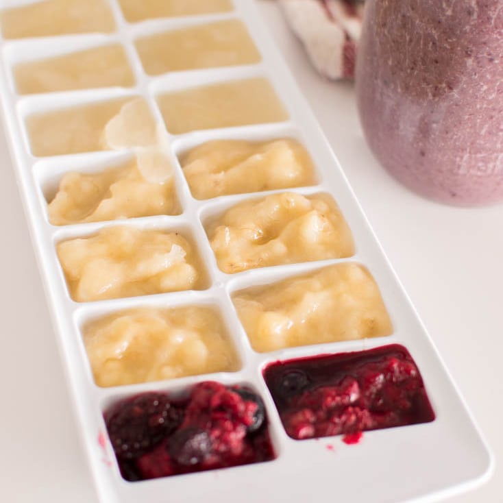 Mashed fruit and almond milk frozen in a white ice cube tray