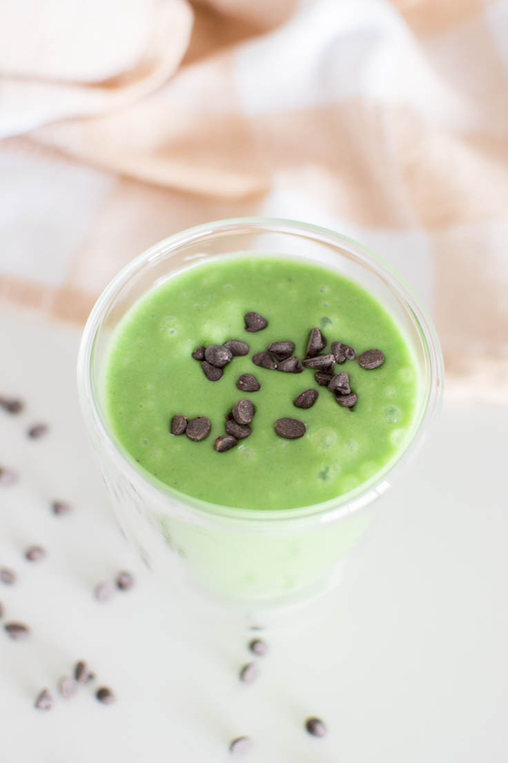 Aerial view of a green milkshake topped with mini chocolate chips