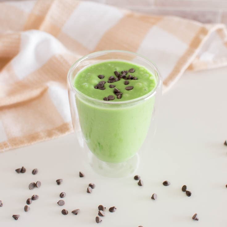 Healthy Shamrock Shake surrounded by a tea towel and miniature chocolate chips