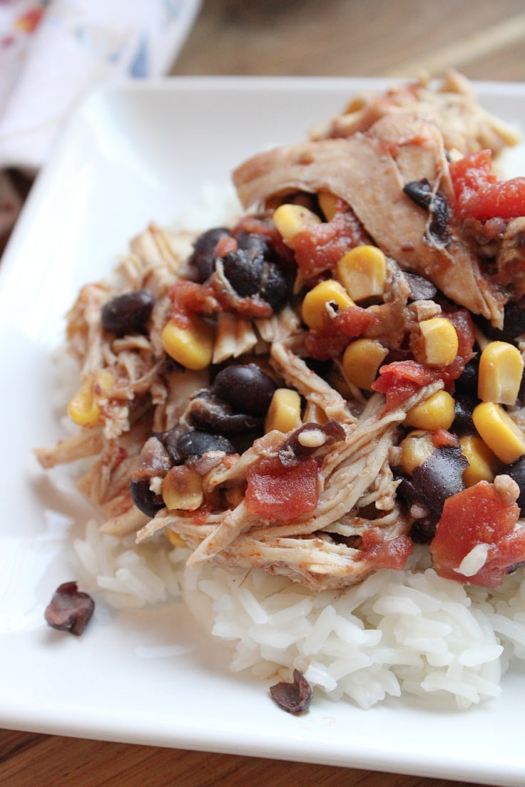 Closeup of southwest chicken with beans, corn, and tomato over rice.