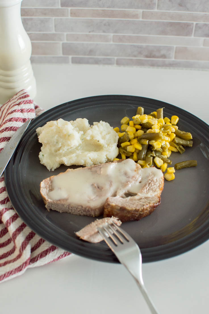 Easy baked pork dinner on a grey plate with side dishes