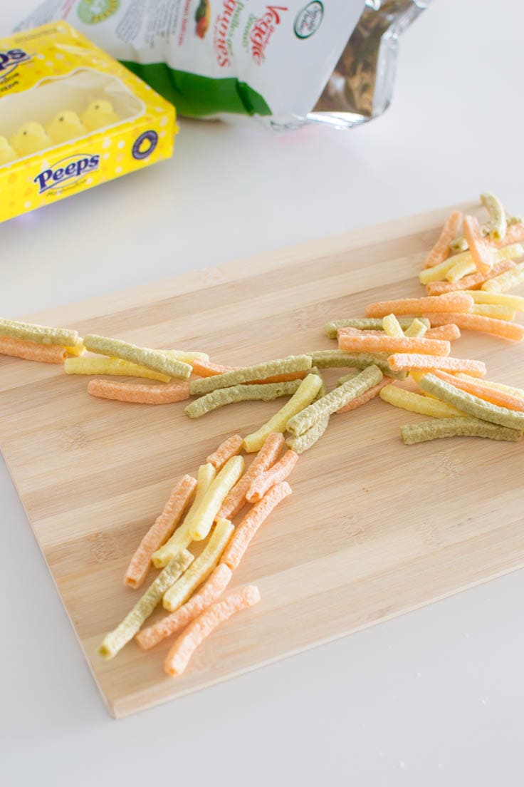 Veggie straws spread out on a wooden platter