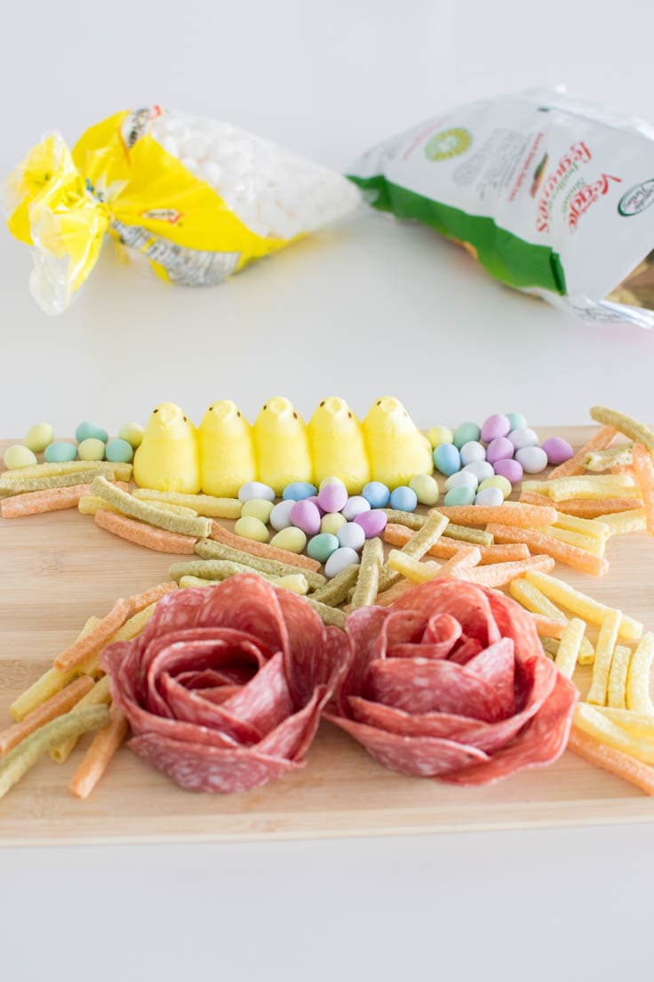 Building a spring charcuterie board with various sweet and savory ingredients and elements