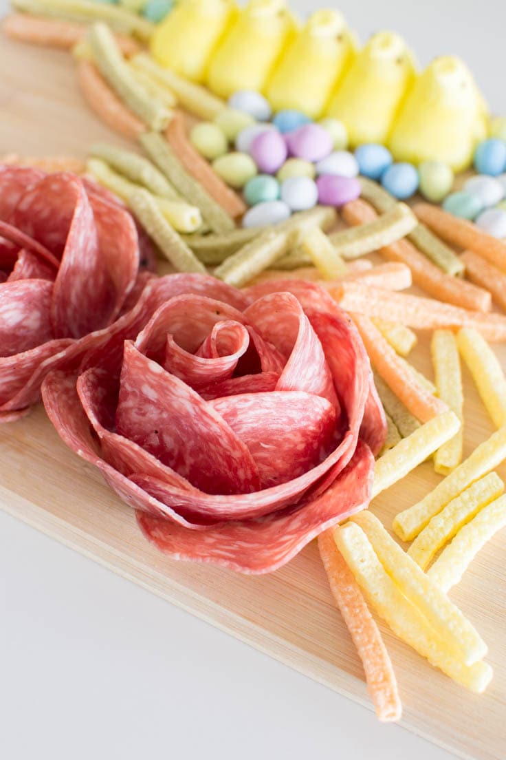 Close-up shot of salami roses, surrounded by other charcuterie elements
