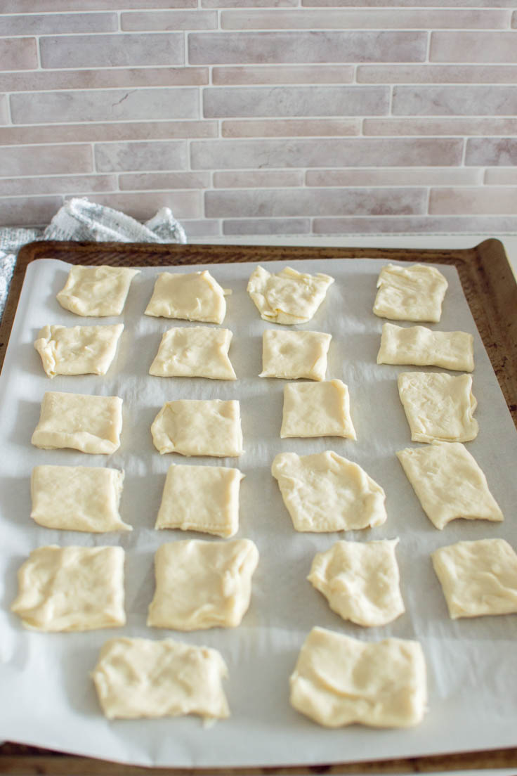Puff pastry cut into squares on a baking sheet