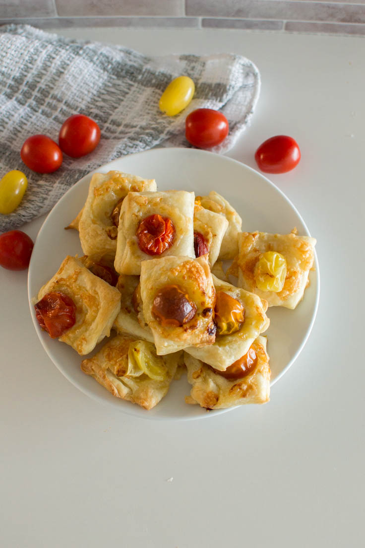 Aerial view of puff pastry tomato tarts on a white plate