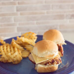 Easy Pork Tenderloin Sliders served on a blue plate with waffle fries