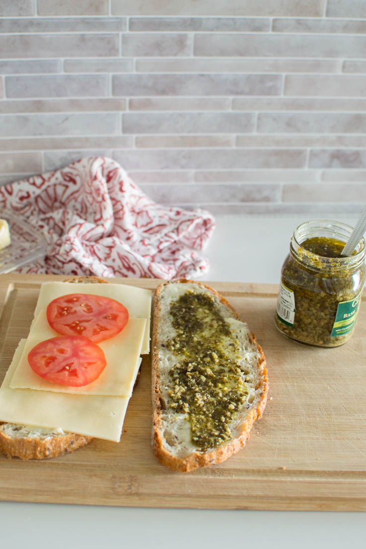Adding pesto sauce on a slice of buttered bread