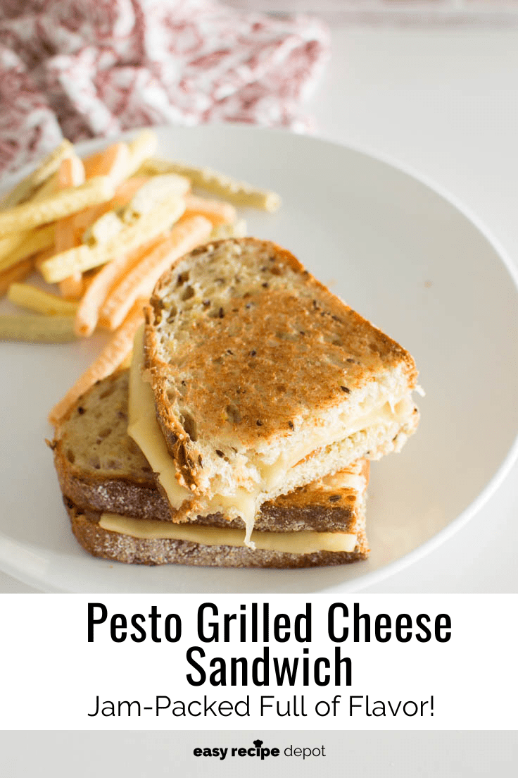 A pesto grilled cheese sandwich cut in half with cheese oozing out of it.