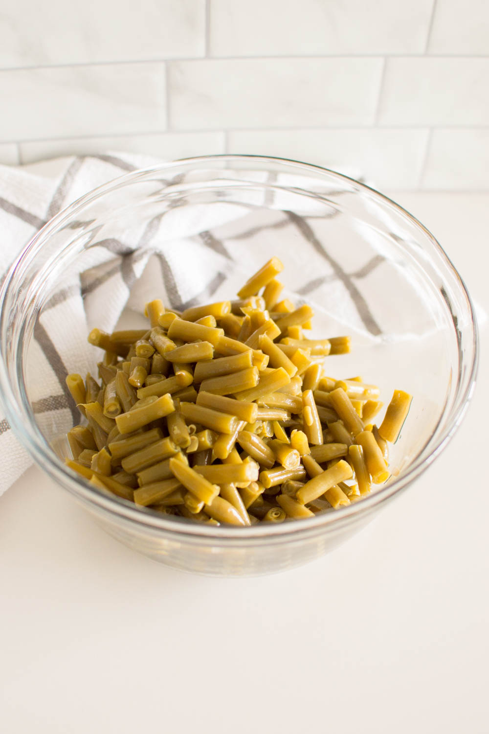 Canned green beans drained and poured into a large glass bowl