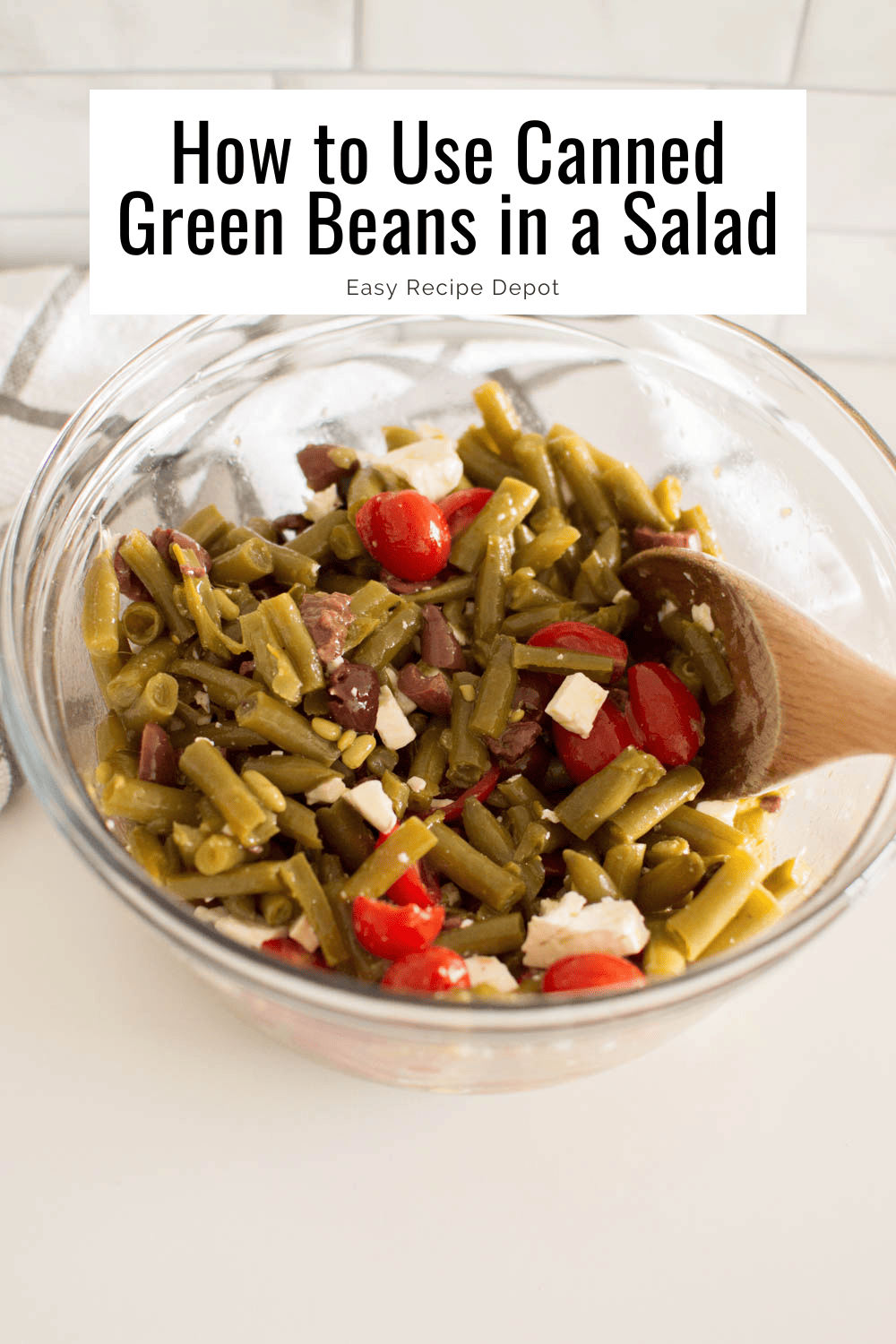 Green beans, feta cheese, olives and cherry tomatoes in a large glass bowl