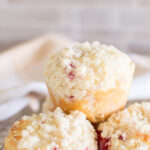 Raspberry Streusel Muffins stacked on top of each other on a wire rack