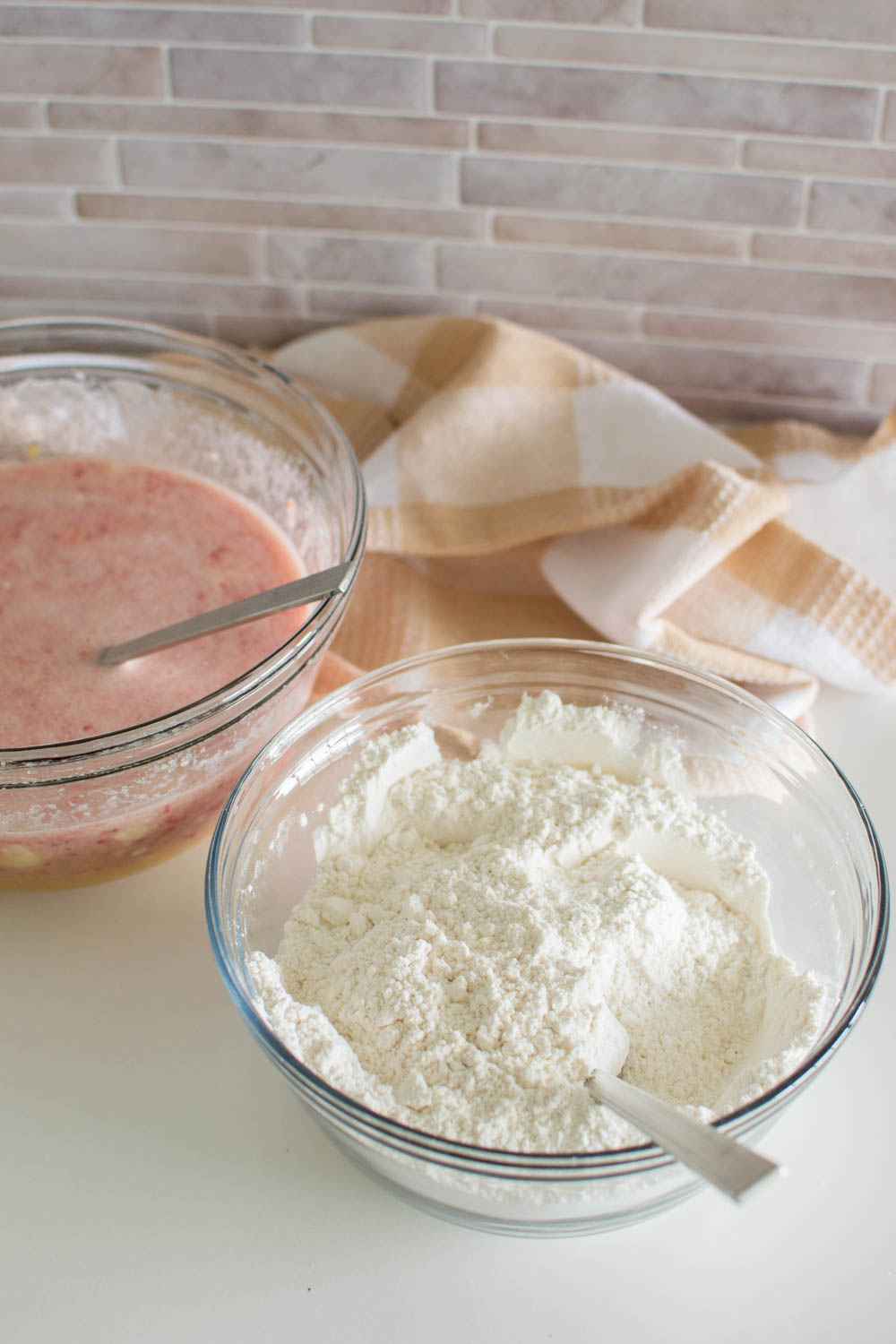 A bowl of wet ingredients and another bowl of dry ingredients to make a strawberry cake