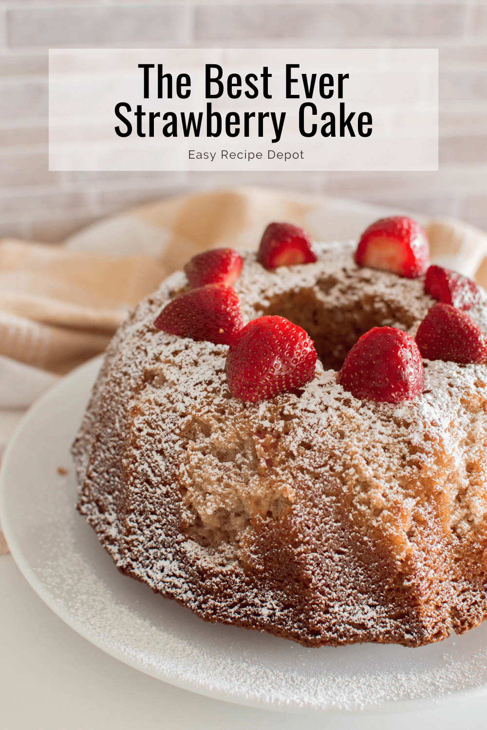 The best ever strawberry bundt cake topped with powdered sugar and sliced strawberries.