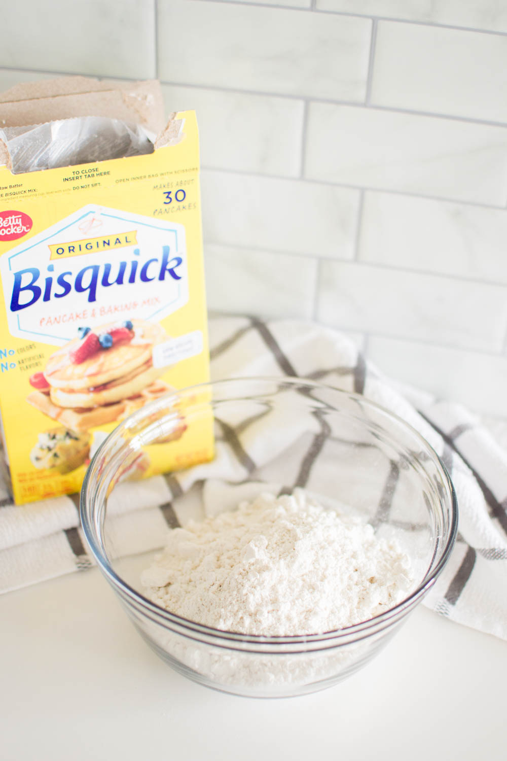 Adding Bisquick mix into a glass bowl