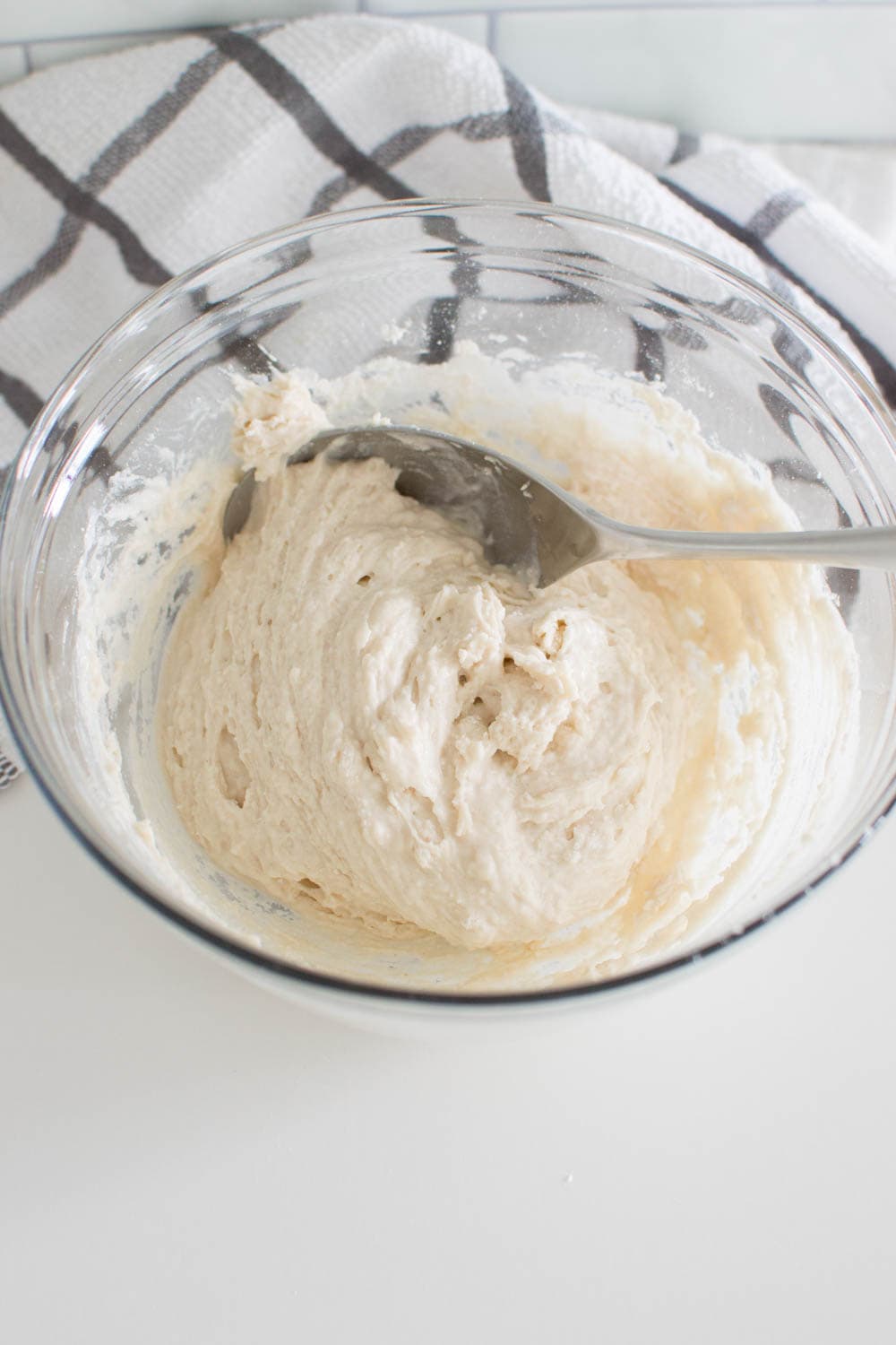 A spoon mixing Bisquick and milk together to form a thick batter