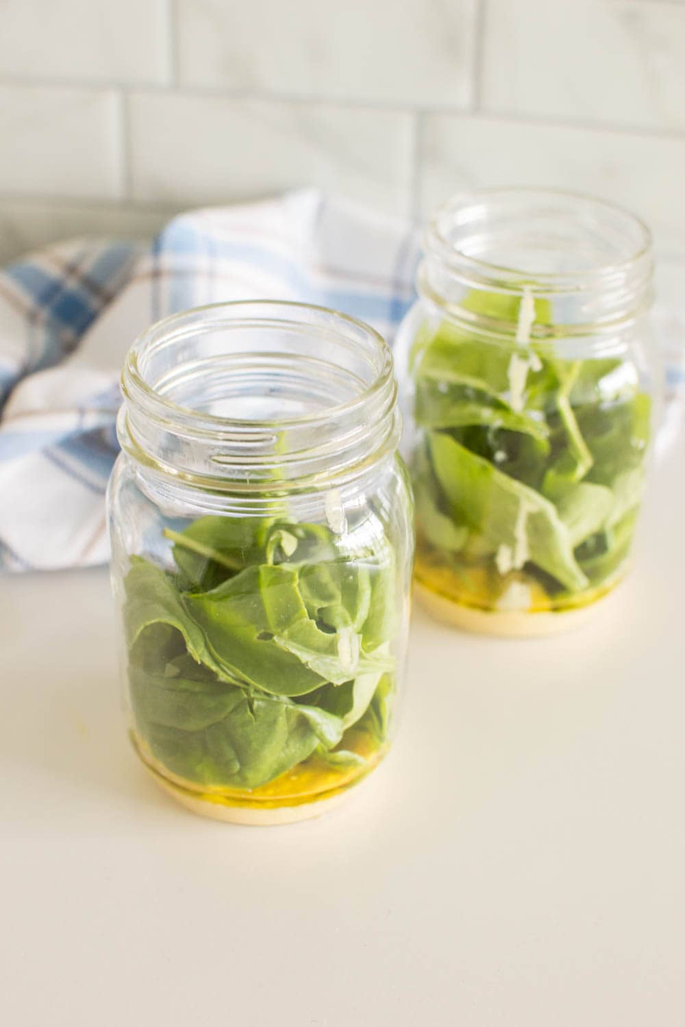 Spinach and dressing in 2 glass mason jars