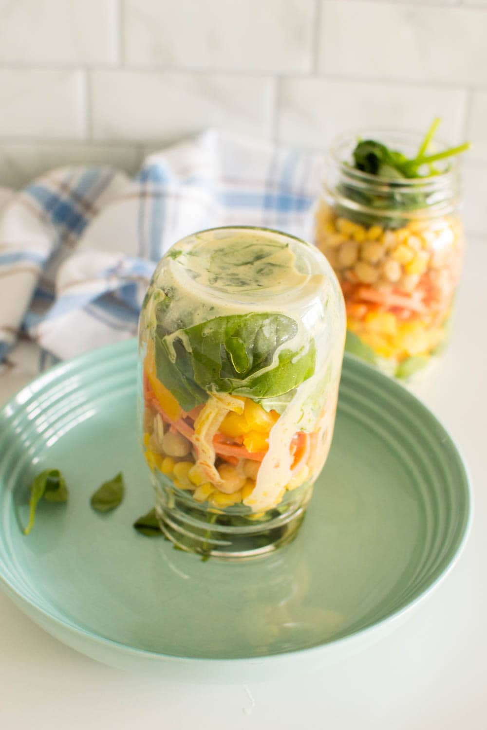 Placing a mason jar salad upside down on a salad plate, ready to be served