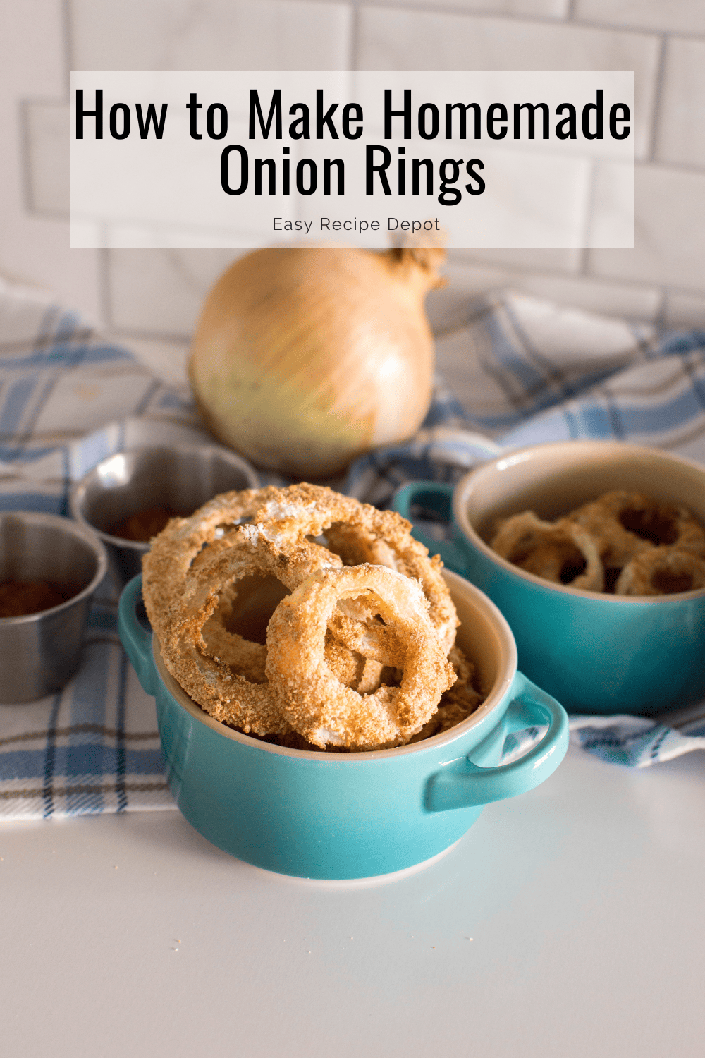 Homemade air fryer onion rings in turquoise bowls, surrounded by ketchup and a plaid tea towel