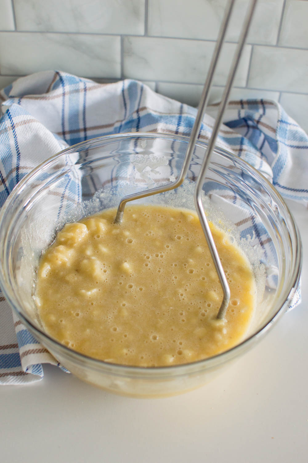 Mashing overripe bananas with the wet ingredients to start an easy homemade banana bread