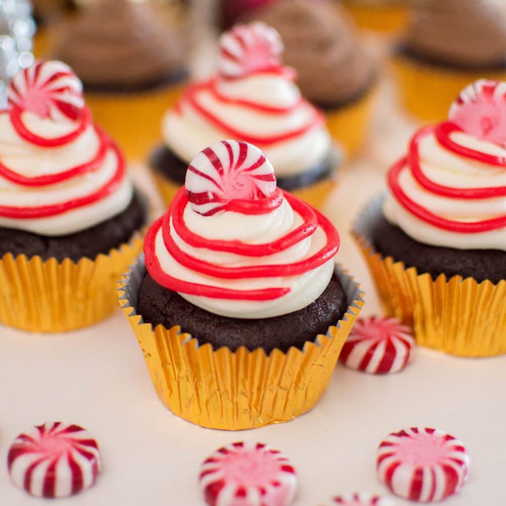 Red and white peppermint frosting on chocolate cupcakes.