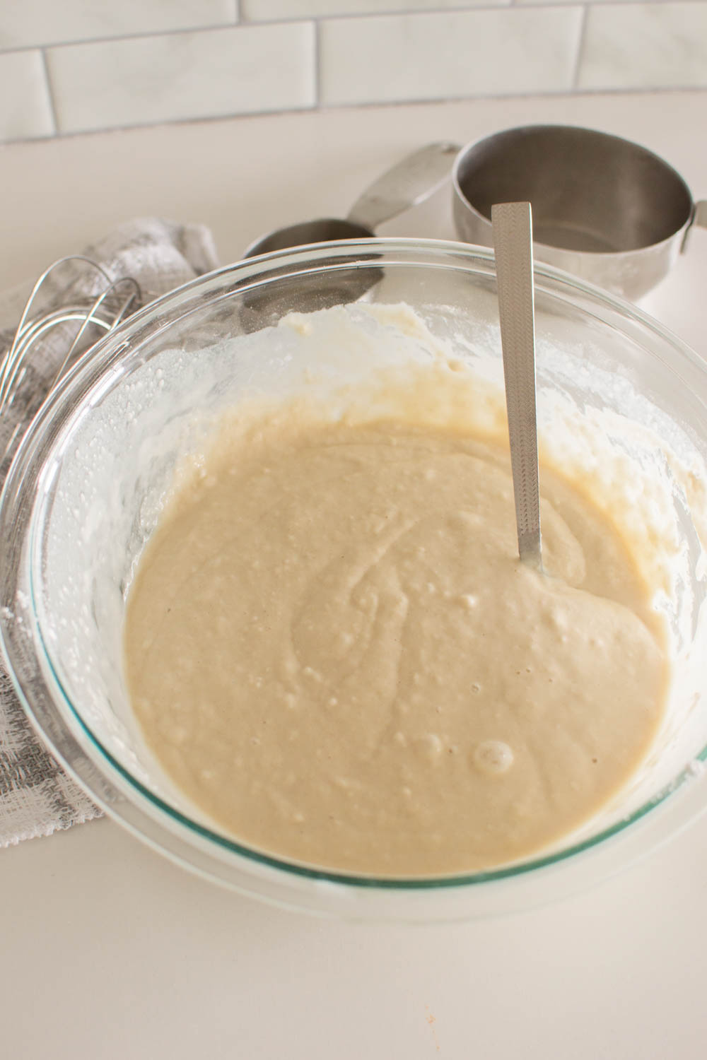 batter to homemade pancakes in a glass bowl